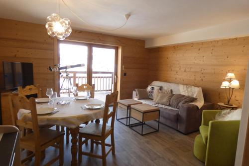 un salon avec une table et un canapé dans l'établissement Appartement neuf et cosy, 4 personnes, 2 chambres - NEIGES05, à Beaufort