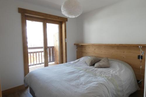 une chambre avec un lit et une grande fenêtre dans l'établissement Appartement neuf et cosy, 4 personnes, 2 chambres - NEIGES05, à Beaufort