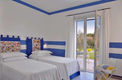 - 2 lits dans une chambre à rayures bleues et blanches dans l'établissement Villa Pandora - Teloni, à Bibbona