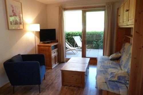 un salon avec un canapé, une table et une télévision dans l'établissement Appartement jolie vue, 6 personnes, 2 chambres - HC04, à Beaufort