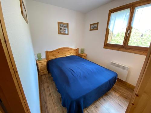 une chambre avec un lit bleu et une fenêtre dans l'établissement Appartement jolie vue, 6 personnes, 2 chambres - HC04, à Beaufort
