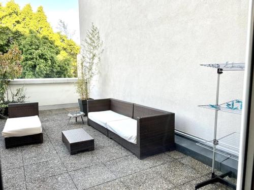 een patio met een bank en stoelen en een raam bij Bright and quiet apartment - free parking in Illzach