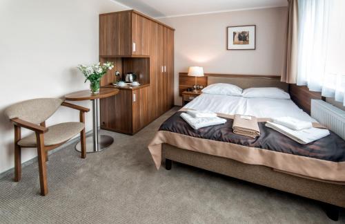 a bedroom with a bed and a table and a chair at Hotel Polanica Resort & Spa in Polanica-Zdrój