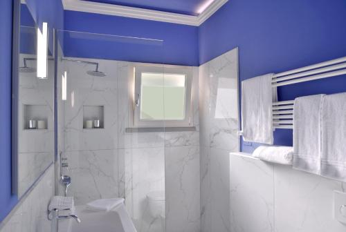 une salle de bain bleue avec des toilettes et un lavabo dans l'établissement Villa Pandora - Teloni, à Bibbona