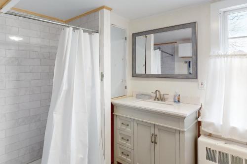uma casa de banho branca com um lavatório e um espelho em Country Cottage em Indian Point