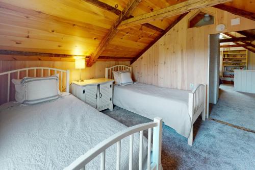 Duas camas num quarto com tectos em madeira em Country Cottage em Indian Point