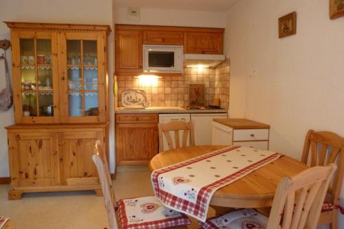 une cuisine avec une table en bois et une table et des chaises dans l'établissement Appartement pied des pistes, 4 personnes, 1 chambre - MONT09, à Beaufort