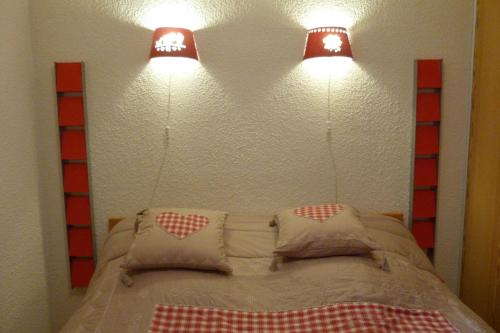 Una cama con dos luces encima. en Appartement pied des pistes, 4 personnes, 1 chambre - MONT09, en Beaufort