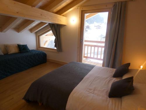 a bedroom with a bed and a large window at Chalet cosy près des pistes, 12 personnes, 4 chambres - CH41 in Beaufort