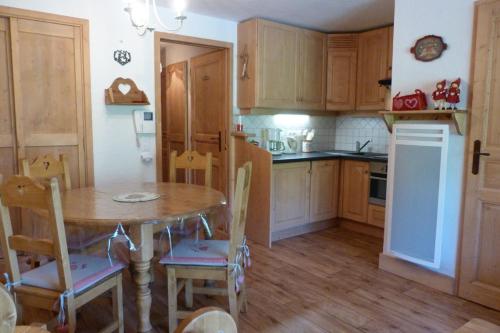 une cuisine avec une table en bois et une table et des chaises dans l'établissement Appartement cosy, 5 personnes, 1 chambre, 1 coin montagne - ECRINI06, à Beaufort
