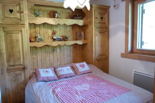 Appartement cosy, 5 personnes, 1 chambre, 1 coin montagne - ECRINI06 في بوفورت: غرفة نوم مع سرير مع وسائد وردية عليه