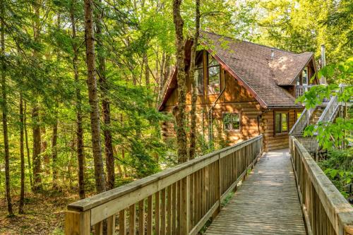 a wooden bridge leading to a cabin in the woods at Mersey River Chalets a nature retreat in Caledonia