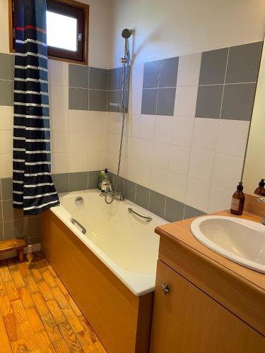 une salle de bain avec une baignoire et un lavabo dans l'établissement Chalet vue panoramique, 11 personnes, 5 chambres - CH47, à Beaufort