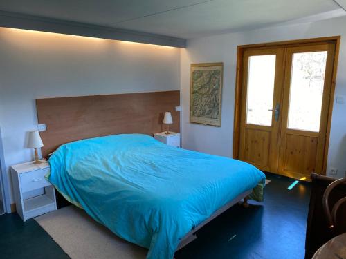 a bedroom with a bed with a blue comforter at Chalet vue panoramique, 11 personnes, 5 chambres - CH47 in Beaufort