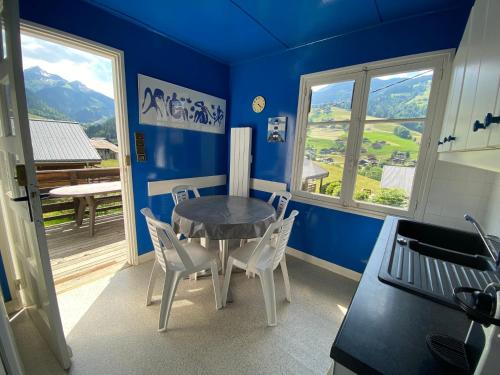 a kitchen with a table and chairs in a room with blue walls at Chalet proche des commerces, 6 personnes, 2 chambres - CH16 in Beaufort