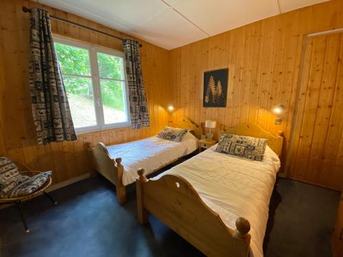 a bedroom with two beds and a window at Chalet proche des commerces, 6 personnes, 2 chambres - CH16 in Beaufort