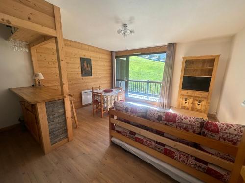 un salon avec un canapé et une grande fenêtre dans l'établissement Appartement cosy rénové, 4 personnes, 1 coin montagne - AR2022, à Beaufort