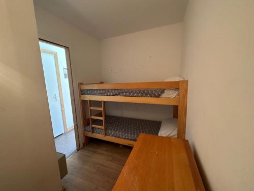 Cette petite chambre comprend 2 lits superposés et une table. dans l'établissement Appartement cosy rénové, 4 personnes, 1 coin montagne - AR2022, à Beaufort