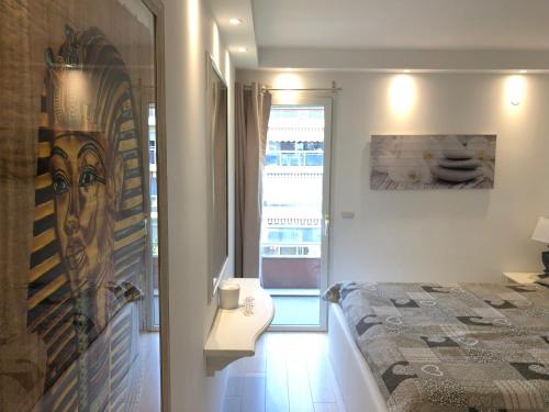 a small bedroom with a bed and a window at Villa d'Este attico con piscina rooftop in Juan-les-Pins