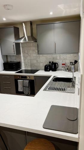 a kitchen with a sink and a stove top oven at Abbey House in Horsham