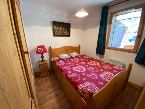 - une chambre avec un lit doté d'un couvre-lit rouge dans l'établissement Appartement chaleureux, 4 personnes, 1 chambre, 1 coin montagne - MONTA11, à Beaufort