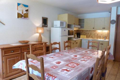 une cuisine avec une table et un réfrigérateur blanc dans l'établissement Appartement pied des pistes, 8 personnes, 3 chambres - CHAM01, à Beaufort