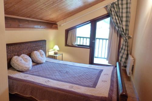une chambre avec un grand lit avec une fenêtre dans l'établissement Appartement pied des pistes, 8 personnes, 3 chambres - CHAM01, à Beaufort
