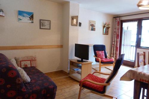 un salon avec une télévision, un canapé et des chaises dans l'établissement Appartement pied des pistes, 8 personnes, 3 chambres - CHAM01, à Beaufort
