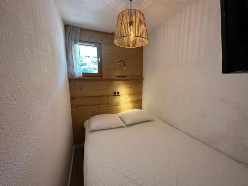 Cette petite chambre comprend un lit et un lustre. dans l'établissement Appartement rénové plein centre, 4 personnes, 1 chambre, 1 coin montagne - VLI37, à Beaufort