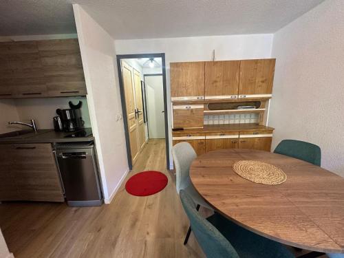 une cuisine avec une table en bois et une salle à manger dans l'établissement Appartement rénové plein centre, 4 personnes, 1 chambre, 1 coin montagne - VLI37, à Beaufort