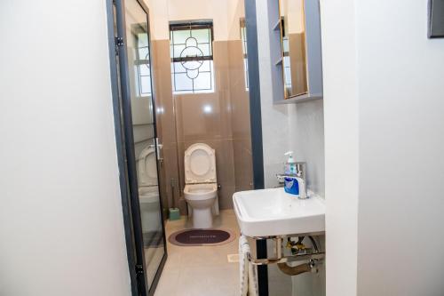 a bathroom with a toilet and a sink at Sana Home by Edmor Suites in Nairobi