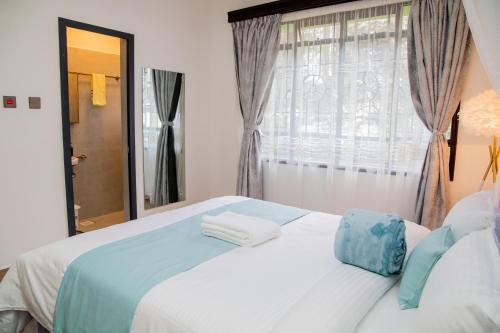 a bedroom with a white bed and a window at Sana Home by Edmor Suites in Nairobi
