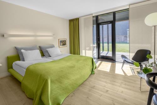 Un dormitorio con una cama con una manta verde. en Nørre Vosborg en Vemb
