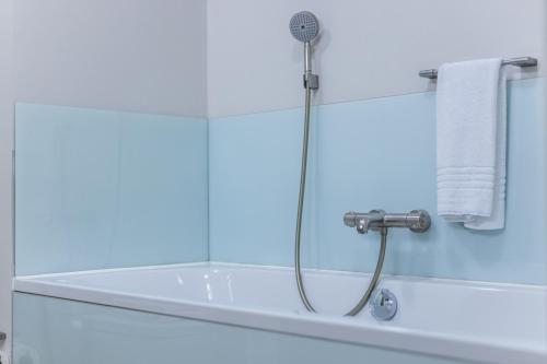 a shower in a bathroom with a bath tub at Nørre Vosborg Hotel & Gastronomi in Vemb