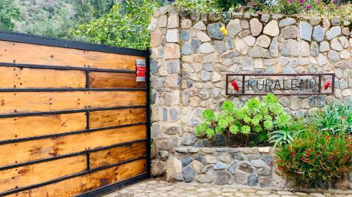 a wooden fence next to a stone wall at KURALEMU Casa de Campo in Curacaví