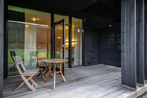 a patio with two chairs and a table on a porch at Nørre Vosborg Hotel & Gastronomi in Vemb
