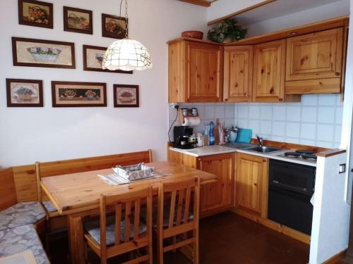 a kitchen with wooden cabinets and a wooden table at Appartamento - Pila Ciel Bleu - Il balcone sulle Alpi in Pila