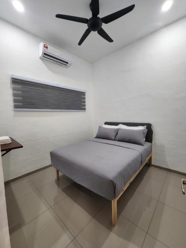 a bedroom with a bed with a ceiling fan at Voon 4 bedroom homestay Mersing 2 in Mersing