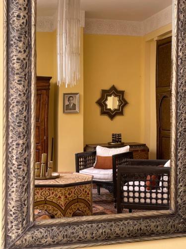 a mirror in a room with a chair and a table at RIAD DAR NAOMI in Marrakech