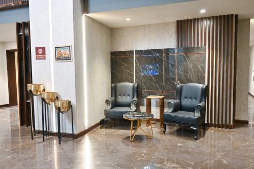 a lobby with two chairs and a table in a building at Jacaranda Heights in Islamabad