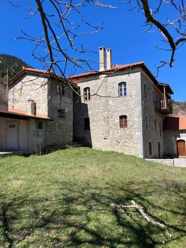 un vieux bâtiment en pierre sur une colline herbeuse dans l'établissement Παραδοσιακή Κατοικία στο Μαίναλο, à Alonistaina