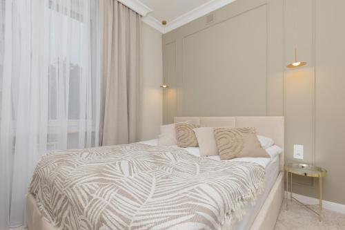 una camera bianca con un grande letto con finestra di Bright & Elegant Apartment Warsaw by Renters a Varsavia