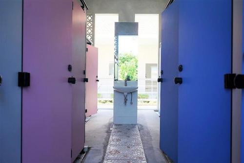 a hallway with a bathroom with a sink in it at Bali Bobo Hostel in Jimbaran