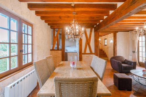 une salle à manger avec une table, des chaises et un lustre dans l'établissement Norman house 160m2 with pool at the Hippodrome, à Deauville