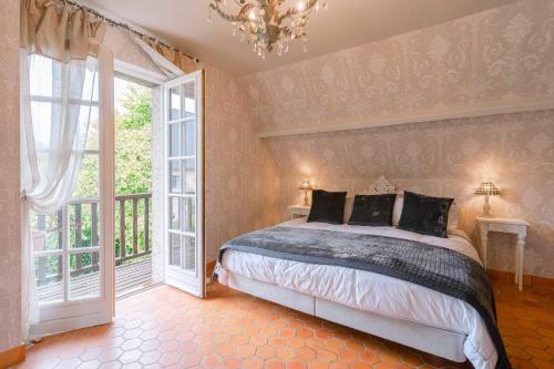 una camera con letto e lampadario a braccio di Magnificent Norman house of 160m2 for 8 people with swimming pool a Deauville