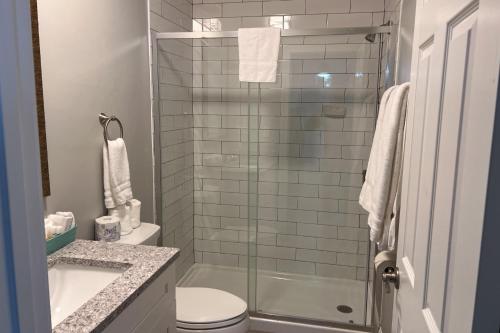 a bathroom with a shower and a toilet and a sink at Marco Island Lakeside Inn in Marco Island