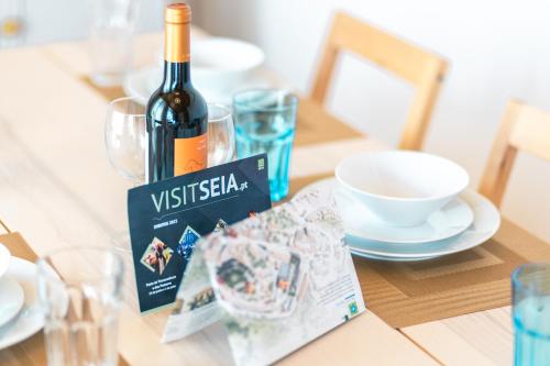 a bottle of wine sitting on a table with a magazine at Eira das Lages in Seia