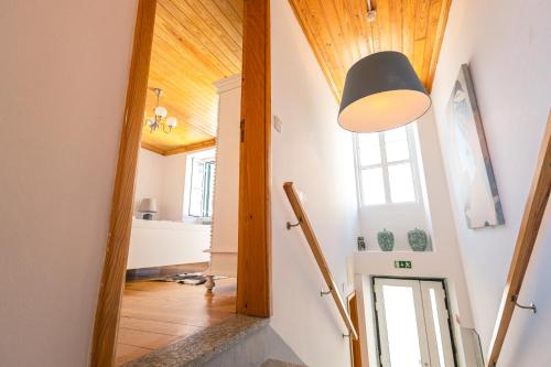 a hallway with a door and a lamp on the wall at Eira das Lages in Seia