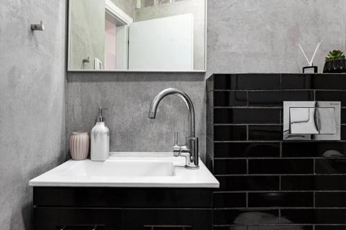 ein Badezimmer mit einem weißen Waschbecken und einem Spiegel in der Unterkunft 3Bedroom Suite with balcony Yona Hotel in Tel Aviv