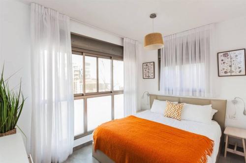 ein Schlafzimmer mit einem Bett und einem großen Fenster in der Unterkunft 3Bedroom Suite with balcony Yona Hotel in Tel Aviv